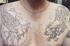 Dragon and fish chest tattoo